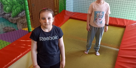 Powiększ grafikę: Dwie dziewczynki na trampolinie.