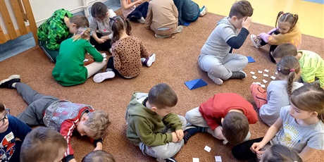 Powiększ grafikę: Grupa dzieci na dywanie grają w grę memory