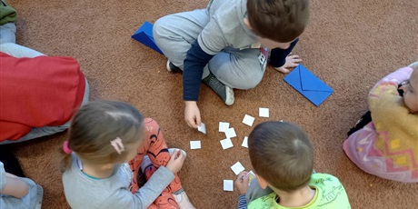 Powiększ grafikę: Grupa dzieci na dywanie grają w grę memory